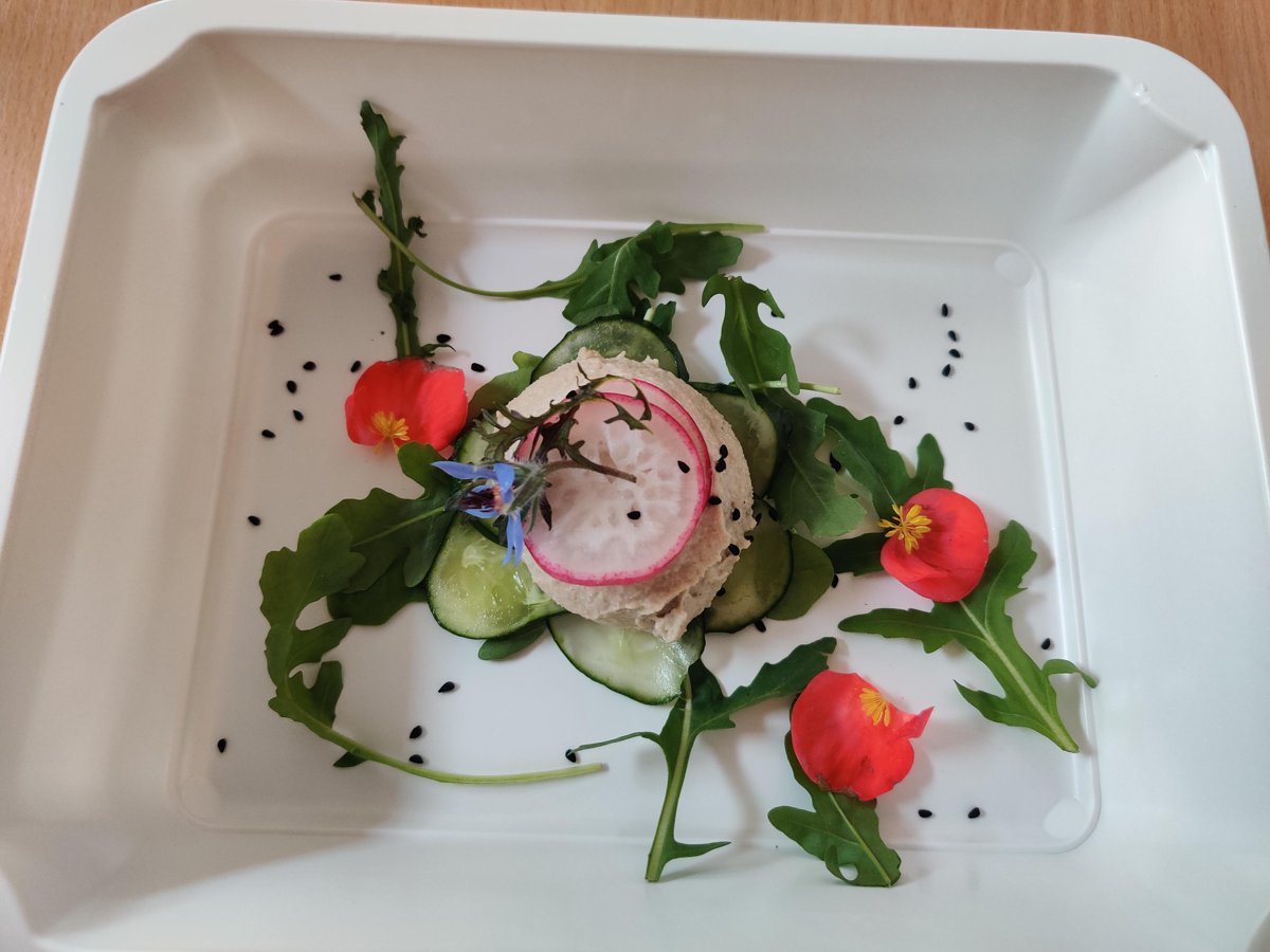 A plated meal-prep starter with pâté, cucumber and edible flowers