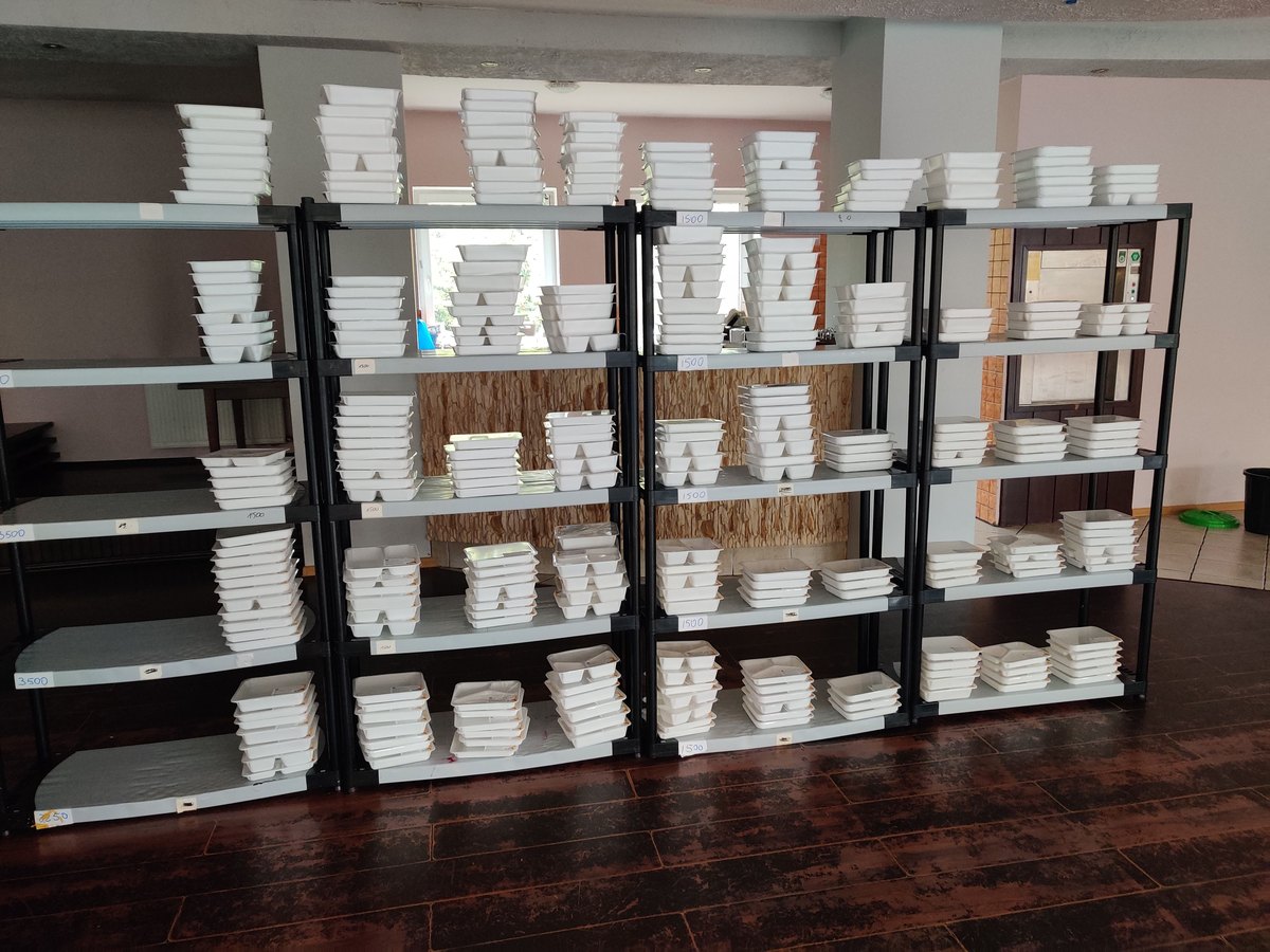 Racks stacked with the day's meal containers, ready to fill